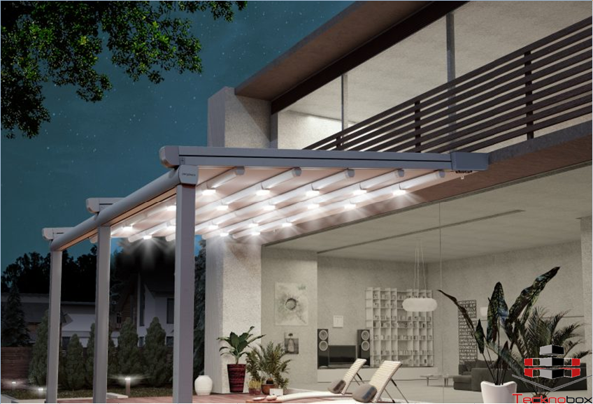 Pergola retractable sur une terrasse la couleur de la structure est grise et celle de la bache est beige elle est illuminer par des Led de couleur blanche